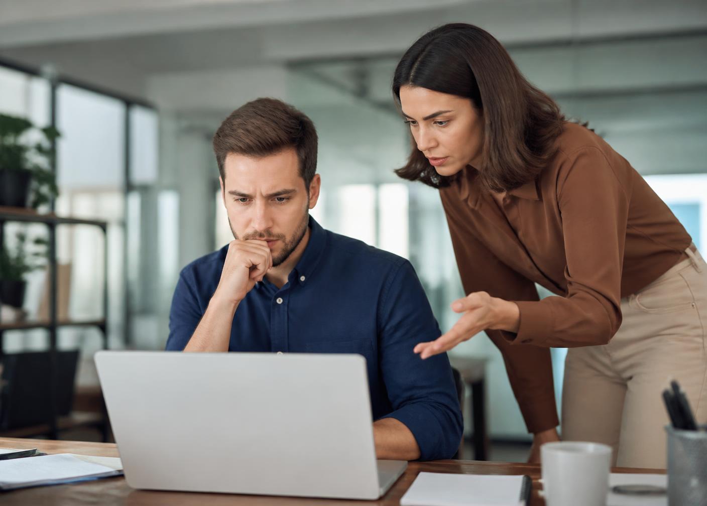 Two colleagues at a laptop searching for email and files that are no longer where they expected