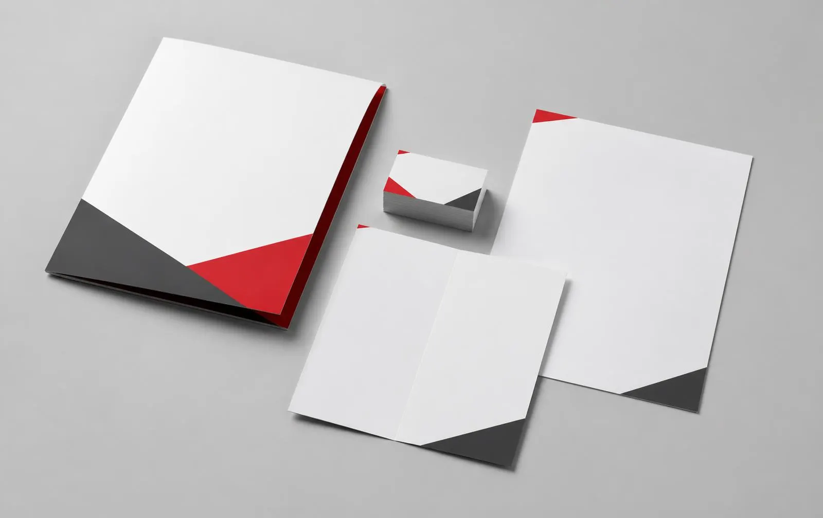 A presentation folder, business cards, brochure and letterhead in charcoal and red
